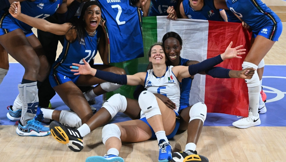 Italy's #06 Monica de Gennaro and Italy's #18 Paola Ogechi Egonu and teammates celebrate after winning the women's volleyball gold medal match between USA and Italy at the South Paris Arena 1 in Paris during the Paris 2024 Olympic Games on August 11, 2024. (Photo by PATRICIA DE MELO MOREIRA / AFP)