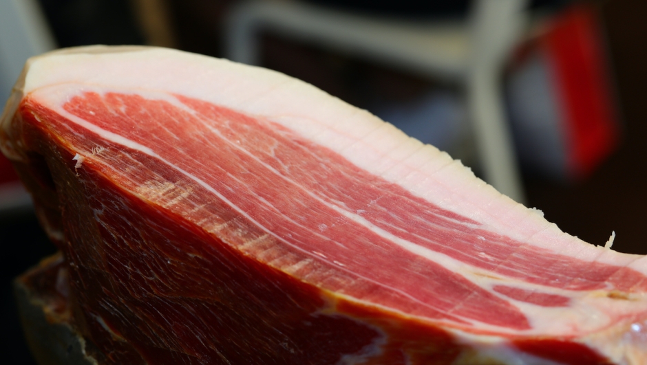 cut of seasoned raw ham with sliced fat white lard in the delicatessen