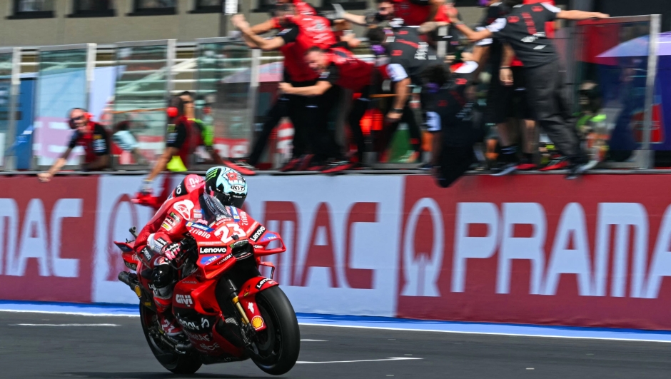 TOPSHOT - Ducati Lenovo Team's Italian rider Enea Bastianini crosses the line and celebrates as he wins the MotoGP Pramac Emilia-Romagna Grand Prix at the Misano World Circuit Marco-Simoncelli in Misano Adriatico, on September 22, 2024. (Photo by Andreas SOLARO / AFP)