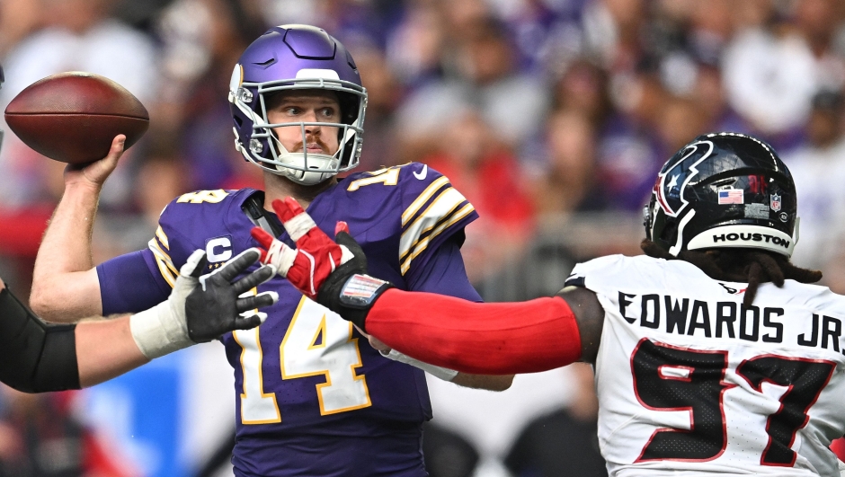 MINNEAPOLIS, MINNESOTA - SEPTEMBER 22: Quarterback Sam Darnold #14 of the Minnesota Vikings passes the ball as Mario Edwards Jr. #97 of the Houston Texans rushes during the third quarter at U.S. Bank Stadium on September 22, 2024 in Minneapolis, Minnesota.   Stephen Maturen/Getty Images/AFP (Photo by Stephen Maturen / GETTY IMAGES NORTH AMERICA / Getty Images via AFP)