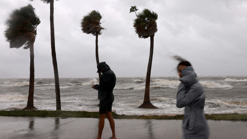 ST PETERSBURG, FLORIDA - SEPTEMBER 2: People walk in the wind and rain next to Tampa Bay as Hurricane Helene churns offshore on September 26, 2024, in St. Petersburg, Florida. Already a Category 3 storm, Helene was expected to gain further strength before making landfall this evening on Floridas northwestern coast. Flash flood warnings extend to northern Georgia and western North Carolina.   Joe Raedle/Getty Images/AFP (Photo by JOE RAEDLE / GETTY IMAGES NORTH AMERICA / Getty Images via AFP)