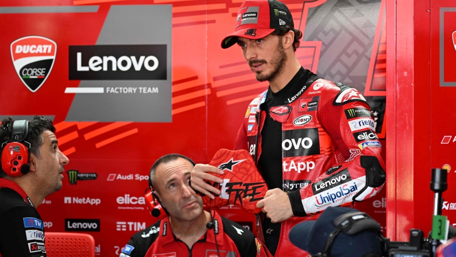 Ducati Lenovo Team's Italian rider Francesco Bagnaia (R) prepares before a free practice session for the 2024 MotoGP race at Pertamina Mandalika International Circuit in Mandalika, West Nusa Tenggara on September 27, 2024. (Photo by SONNY TUMBELAKA / AFP)