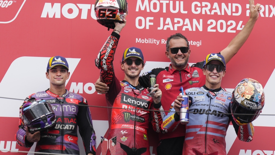 Italian rider Francesco Bagnaia of Ducati Lenovo Team, centre, celebrates on the podium after winning the MotoGP race alongside 2nd placed Spanish rider Jorge Martin of Prima Pramac Racing, left, and 3rd placed Spanish rider Marc Marquez of Gresini Racing MotoGP at the Twin Ring Motegi circuit in Motegi, north of Tokyo, Japan, Sunday, Oct. 6, 2024, (AP Photo/Hiro Komae)