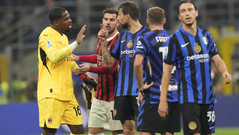 AC Milan's goalkeeper Mike Maignan, left, and Inter Milan's Francesco Acerbi, centre, argue after the Serie A soccer match between Inter Milan and AC Milan at the San Siro stadium in Milan, Italy, Sunday, Sept.22, 2024. (AP Photo/Luca Bruno)