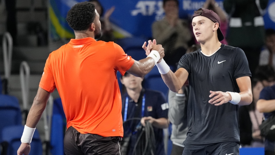 Arthur Fils of France, left, shakes hands with Holger Rune of Denmark after defeating him during their men's singles semifinal match at the Japan Open tennis tournament on Monday, Sept. 30, 2024, at Ariake Coliseum, in Tokyo, Japan. (AP Photo/Eugene Hoshiko)