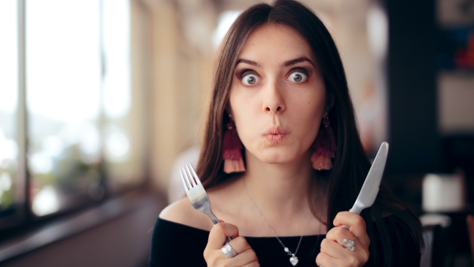 Greedy impatient girl waiting for her dish in a restaurant