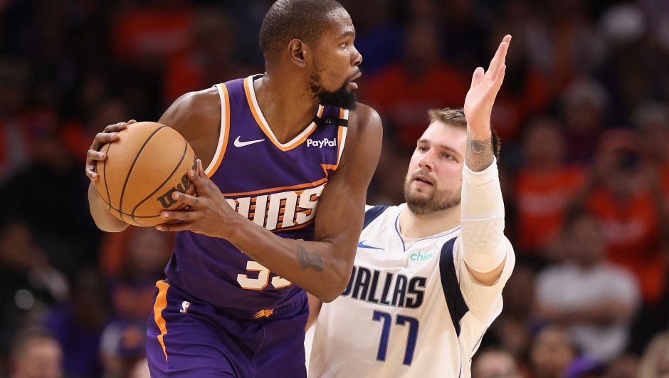 PHOENIX, ARIZONA - OCTOBER 26: Kevin Durant #35 of the Phoenix Suns looks to pass around Luka Doncic #77 of the Dallas Mavericks during the second half of the NBA game at Footprint Center on October 26, 2024 in Phoenix, Arizona. The Suns defeated the Mavericks 114-102. NOTE TO USER: User expressly acknowledges and agrees that, by downloading and/or using this photograph, user is consenting to the terms and conditions of the Getty Images License Agreement.   Christian Petersen/Getty Images/AFP (Photo by Christian Petersen / GETTY IMAGES NORTH AMERICA / Getty Images via AFP)