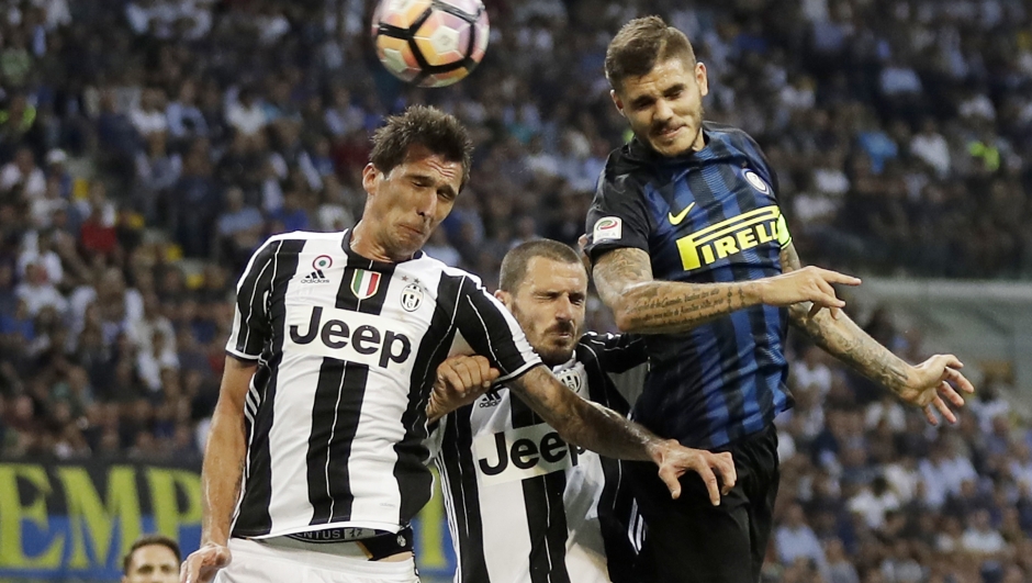 Inter Milan's Mauro Icardi, right, scores a goal as Juventus' Mario Mandzukic tries to stop him during the Serie A soccer match between Inter Milan and Juventus at the San Siro stadium in Milan, Italy, Sunday, Sept. 18, 2016. (AP Photo/Antonio Calanni)