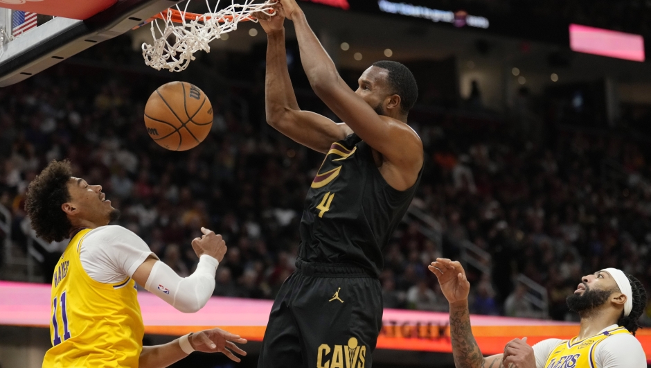 Cleveland Cavaliers forward Evan Mobley (4) dunks between Los Angeles Lakers center Jaxson Hayes (11) and forward Anthony Davis, right, in the second half of an NBA basketball game, Wednesday, Oct. 30, 2024, in Cleveland. (AP Photo/Sue Ogrocki)