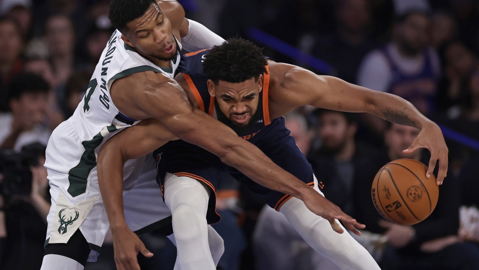 Milwaukee Bucks forward Giannis Antetokounmpo reaches for the ball over New York Knicks center Karl-Anthony Towns, right, during the first half of an NBA basketball game Friday, Nov. 8, 2024, in New York. (AP Photo/Adam Hunger)