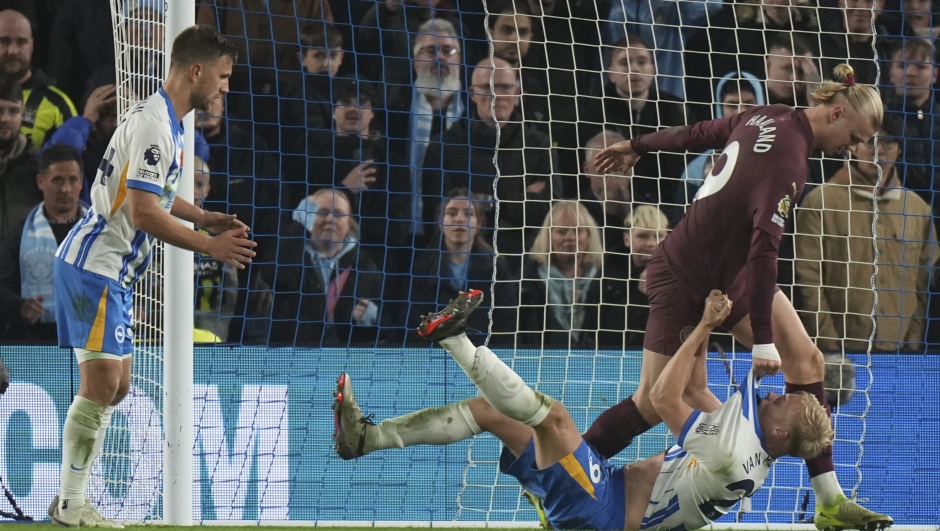 Manchester City's Erling Haaland grabs Brighton's Jan Paul van Hecke during the English Premier League soccer match between Brighton and Manchester City at Falmer Stadium in Brighton, England, Saturday, Nov. 9, 2024. (AP Photo/Alastair Grant)