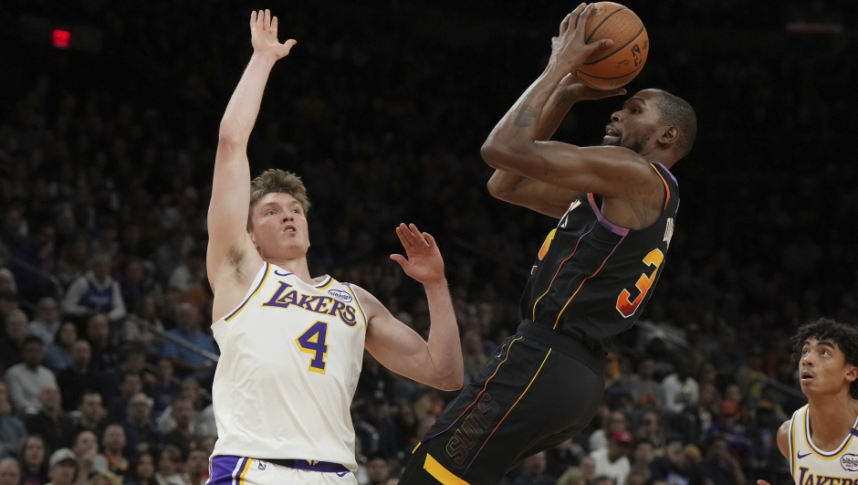 Los Angeles Lakers guard Dalton Knecht (4) commits a foul on Phoenix Suns forward Kevin Durant during the first half of an NBA basketball game, Tuesday, Nov. 26, 2024, in Phoenix. (AP Photo/Rick Scuteri)