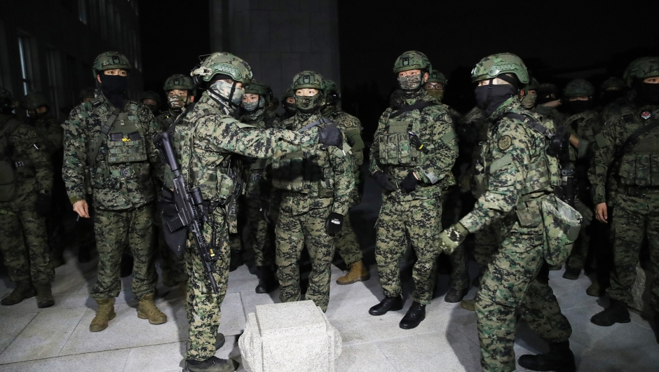 SEOUL, SOUTH KOREA - DECEMBER 03: South Korean soldiers try get into the national assembly on December 04, 2024 in Seoul, South Korea. South Korean lawmakers voted to lift the declaration of emergency martial law announced earlier by President Yoon Suk Yeol in a televised speech. Since taking office two years ago, Mr Yoon has struggled to push his agendas against an opposition-controlled parliament. (Photo by Chung Sung-Jun/Getty Images)