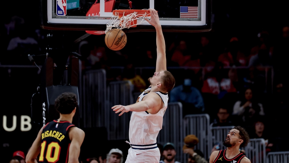 epa11765876 Denver Nuggets center Nikola Jokic (C) of Serbia dunks over Atlanta Hawks forward Zaccharie Risacher (L) of France and Atlanta Hawks guard Trae Young (R) during the second half of an NBA basketball game between the Denver Nuggets and the Atlanta Hawks in Atlanta, Georgia, USA, 08 December 2024.  EPA/ERIK S. LESSER  SHUTTERSTOCK OUT