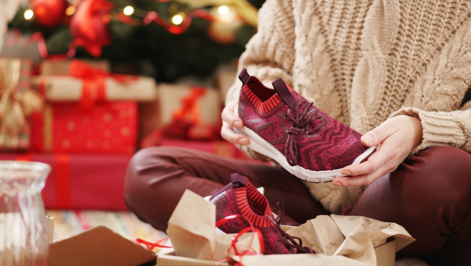 Woman decorating Christmas presents. Preparing present for christmas eve at home.