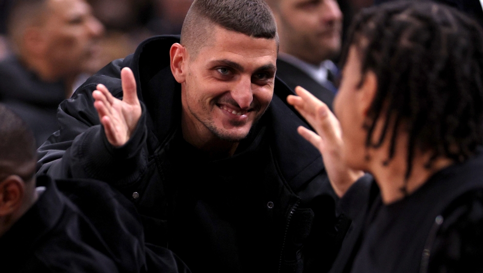 PARIS, FRANCE - JANUARY 11:  Marco Verratti and Ethan Mbappe speak during the NBA match between Brooklyn Nets and Cleveland Cavaliers at The Accor Arena on January 11, 2024 in Paris, France.  (Photo by Dean Mouhtaropoulos/Getty Images)