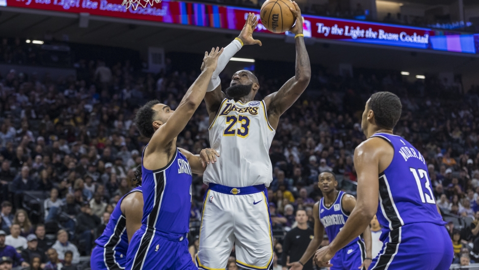 Los Angeles Lakers forward LeBron James (23) makes a layup over Sacramento Kings forward Trey Lyles (41) during the first half of an NBA basketball game Saturday, Dec. 21, 2024, in Sacramento, Calif. (AP Photo/Sara Nevis)