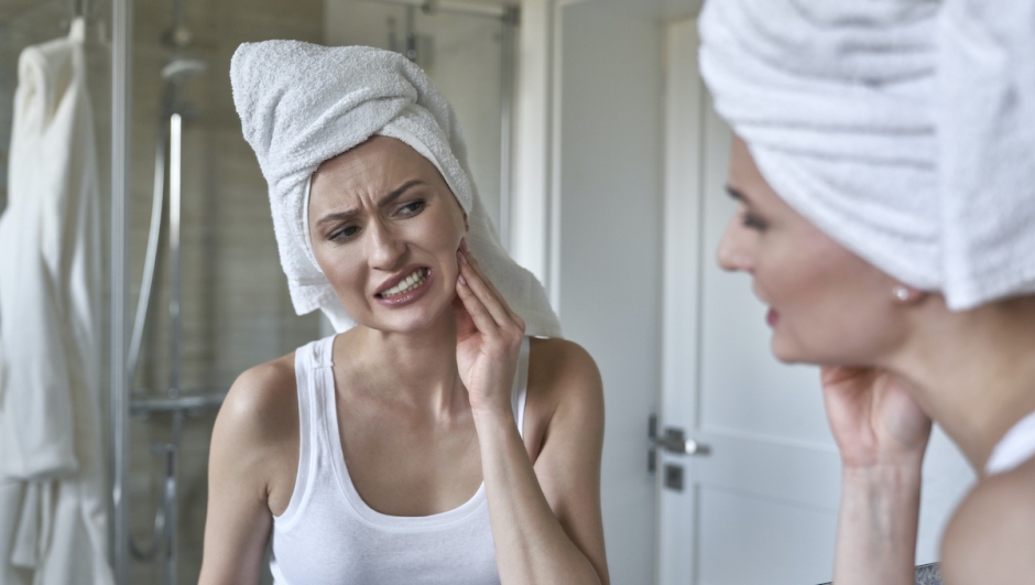 Caucasian woman  in the bathroom having a strong toothache