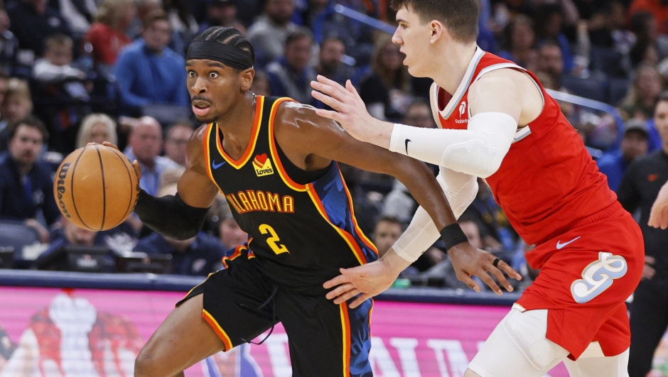 Oklahoma City Thunder guard Shai Gilgeous-Alexander (2) drives past Memphis Grizzlies forward Jake LaRavia, right, during the first half of an NBA basketball game Sunday, Dec. 29, 2024, in Oklahoma City. (AP Photo/Nate Billings)