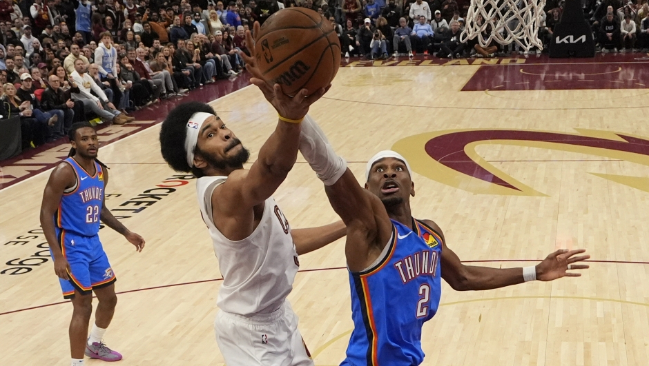 Cleveland Cavaliers center Jarrett Allen (31) reaches for a rebound with Oklahoma City Thunder guard Shai Gilgeous-Alexander (2) in the second half of an NBA basketball game, Wednesday, Jan. 8, 2025, in Cleveland. (AP Photo/Sue Ogrocki)