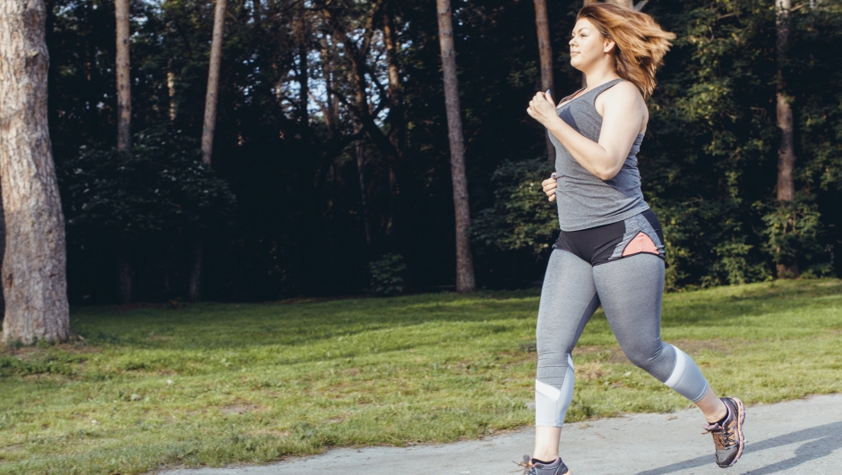 Overweight woman running in the park . Weight loss concept.