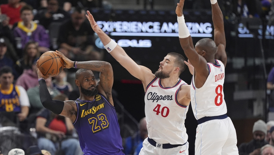 Los Angeles Lakers forward LeBron James, left, tires to pass as Los Angeles Clippers center Ivica Zubac, center, and guard Kris Dunn defend during the second half of an NBA basketball game, Sunday, Jan. 19, 2025, in Inglewood, Calif. (AP Photo/Mark J. Terrill)