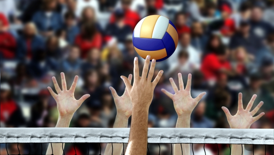 Volleyball spike with hands blocking over the net