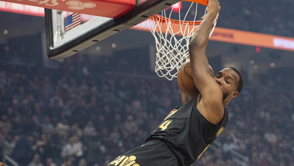 Cleveland Cavaliers' Evan Mobley (4) dunks against the New York Knicks during the first half of an NBA basketball game in Cleveland, Friday, Feb. 21, 2025. (AP Photo/Phil Long)