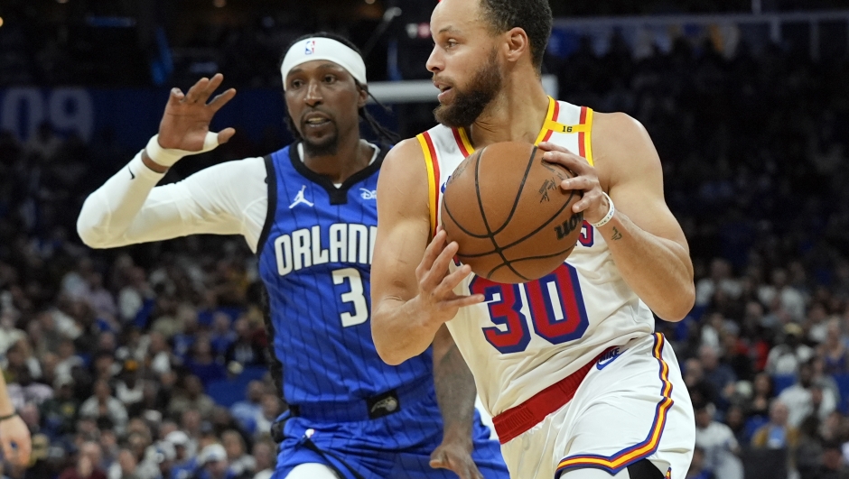 Golden State Warriors guard Stephen Curry (30) drives past Orlando Magic guard Kentavious Caldwell-Pope (3) during the second half of an NBA basketball game, Thursday, Feb. 27, 2025, in Orlando, Fla. (AP Photo/John Raoux)