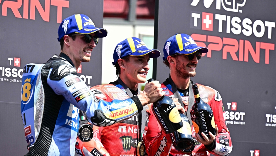 First-placed Ducati Lenovoi Team's Spanish MotoGP rider Marc Marquez (C), second-placed BK8 Gresini Racing MotoGP team's Spanish MotoGP rider Alex Marquez (L) and third-placed Ducati Lenovo Team's Italian MotoGP rider Francesco Bagnaia (R) celebrate after the sprint on the eve of the Italian Moto GP Grand Prix at Mugello circuit, in Mugello, near Florence, on June 21, 2025. (Photo by Tiziana FABI / AFP)