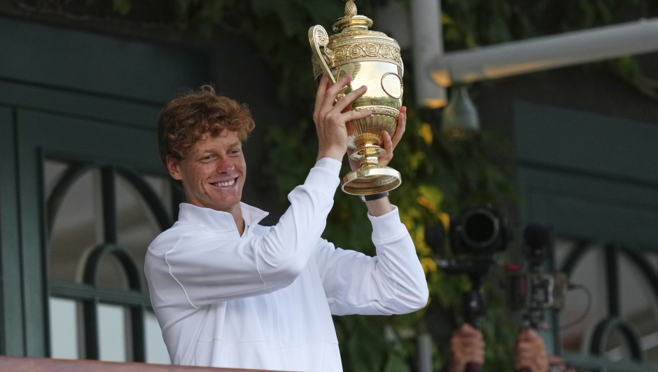 Italy's Jannik Sinner shows the trophy from the balcony of Centre Court after beating Carlos Alcaraz of Spain to win the men's singles final at the Wimbledon Tennis Championships in London, Sunday, July 13, 2025. (AP Photo/Joanna Chan)