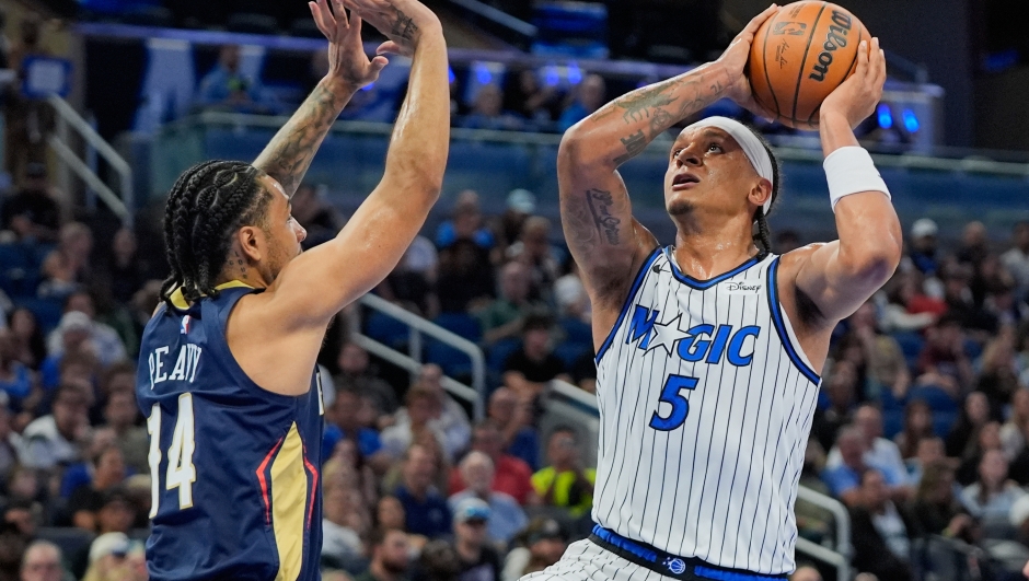 Orlando Magic forward Paolo Banchero (5) shoots over New Orleans Pelicans forward Micah Peavy (14) during the first half of an NBA preseason basketball game, Thursday, Oct. 16, 2025, in Orlando, Fla. (AP Photo/John Raoux)