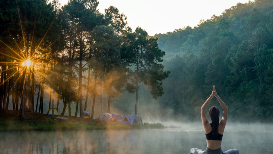 Young woman practicing yoga in the nature.female happiness. Landscape background