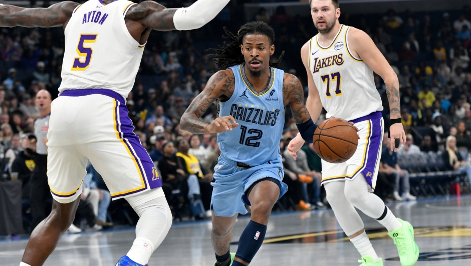 Memphis Grizzlies guard Ja Morant (12) handles the ball between Los Angeles Lakers center Deandre Ayton (5) and guard Luka Doncic (77) in the first half of an NBA Cup basketball game Friday, Oct. 31, 2025, in Memphis, Tenn. (AP Photo/Brandon Dill)
