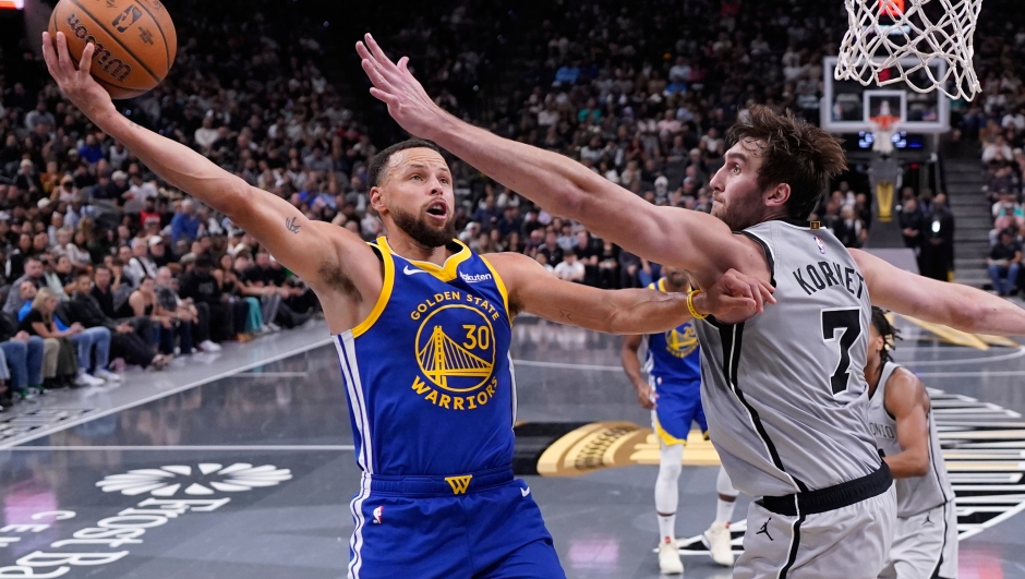 Golden State Warriors guard Stephen Curry (30) drives to the basket against San Antonio Spurs center Luke Kornet (7) during the second half of an NBA Cup basketball game in San Antonio, Friday, Nov. 14, 2025. (AP Photo/Eric Gay)