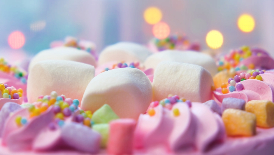 Arranged cream marshmallow cake for festive event. Sweet food, perfect for children's parties. Details of dessert table. Wedding accessories in a soft pink presentation. Decoration wedding party