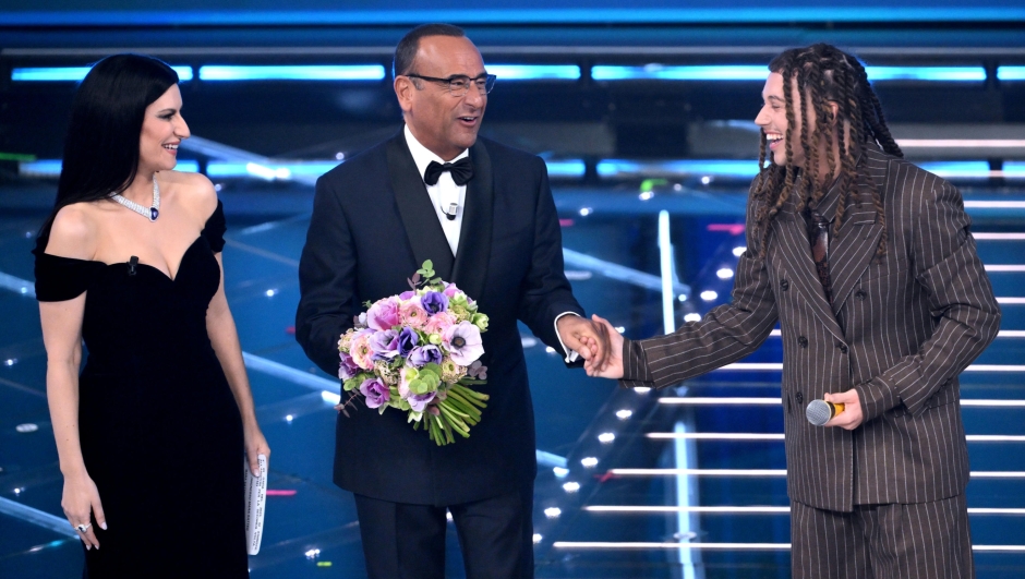 Sanremo Festival host and artistic director Carlo Conti (C)with Italian singer Laura Pausini (L) and Italian singer Sayf (R) on stage at the Ariston theatre during the 76th Sanremo Italian Song Festival, Sanremo, Italy, 24 February 2026. The Music Festival runs from 24 to 28 February 2026. ANSA/ETTORE FERRARI