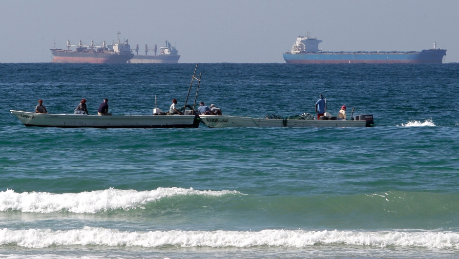 FILE - Fishermen work in front of oil tankers south of the Strait of Hormuz Jan. 19, 2012, offshore the town of Ras Al Khaimah in United Arab Emirates. (AP Photo/Kamran Jebreili, File)