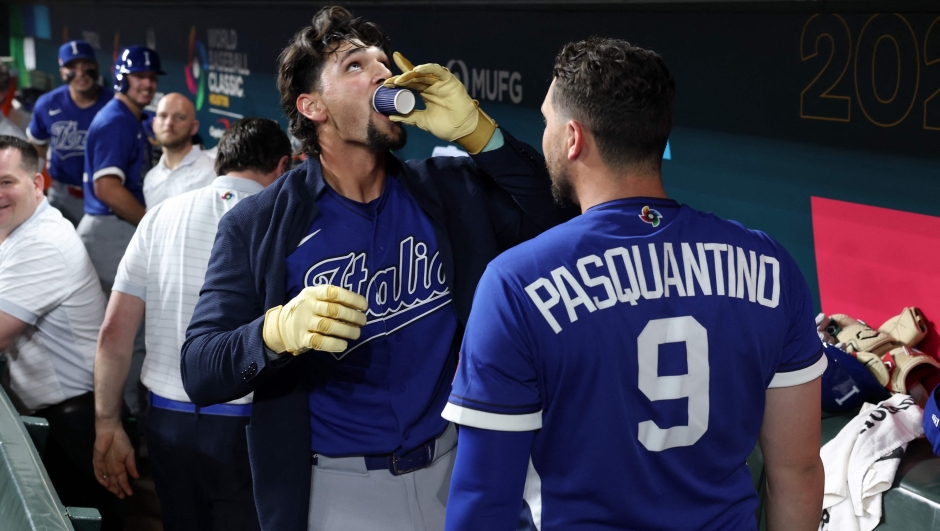  Jac Caglianone #14 of Team Italy takes a shot of espresso as he celebrates with teammate Vinnie Pasquantino #9 in the dugout after hitting a solo home run against Team United States in the fourth inning during the 2026 World Baseball Classic at Daikin Park on March 10, 2026 in Houston, Texas.   Kenneth Richmond/Getty Images/AFP (Photo by Kenneth Richmond / GETTY IMAGES NORTH AMERICA / Getty Images via AFP)