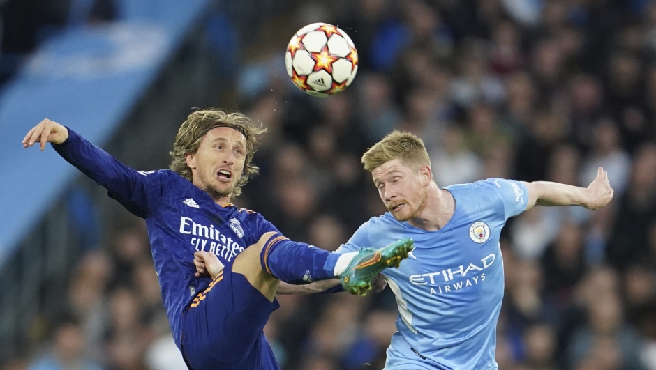 Manchester City's Kevin De Bruyne, right, fights for the ball with Real Madrid's Luka Modric during the Champions League semi final, first leg soccer match between Manchester City and Real Madrid at the Etihad stadium in Manchester, England, Tuesday, April 26, 2022. (AP Photo/Jon Super)