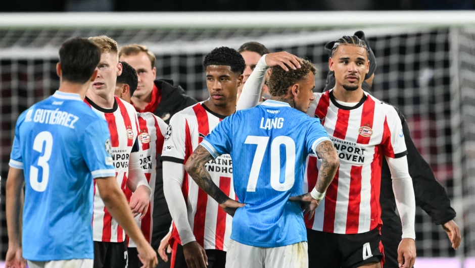 PSV Eindhoven's Dutch defender #04 Armando Obispo (R) hugs Napoli's Dutch forward #70 Noa Lang (2nd R) at the end of the UEFA Champions League, league phase football match between PSV Eindhoven and Napoli at the Philips Stadium, in Eindhoven, on October 21, 2025. PSV Eindhoven wins 6 - 2 against Napoli. (Photo by NICOLAS TUCAT / AFP)