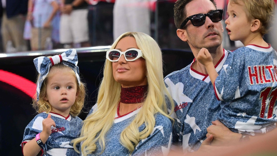 TOPSHOT - US socialite Paris Hilton with her husband Carter Reum and children Phoenix Hilton-Reum and London Hilton-Reum attend the 2026 World Cup Group D football match between Turkey and USA at the Los Angeles Stadium in Inglewood on June 25, 2026.  (Photo by Frederic J. Brown / AFP)
