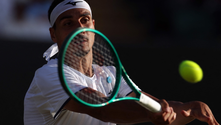 Italy's Lorenzo Sonego (BOTTOM) returns to US player Taylor Fritz during their men's singles third round tennis match on the sixth day of the 2026 Wimbledon Championships at The All England Lawn Tennis and Croquet Club in Wimbledon, southwest London, on July 4, 2026. (Photo by Adrian DENNIS / AFP) / RESTRICTED TO EDITORIAL USE