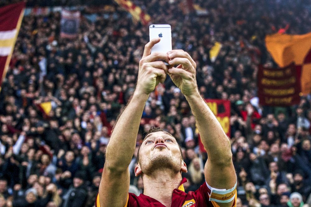 Francesco Totti of AS Roma selfie Apple iPhone during the Serie A match between AS Roma and Lazio Roma on January 11,2014 at the Stadio Olimpico in Rome, Italy.(Photo by VI Images via Getty Images)