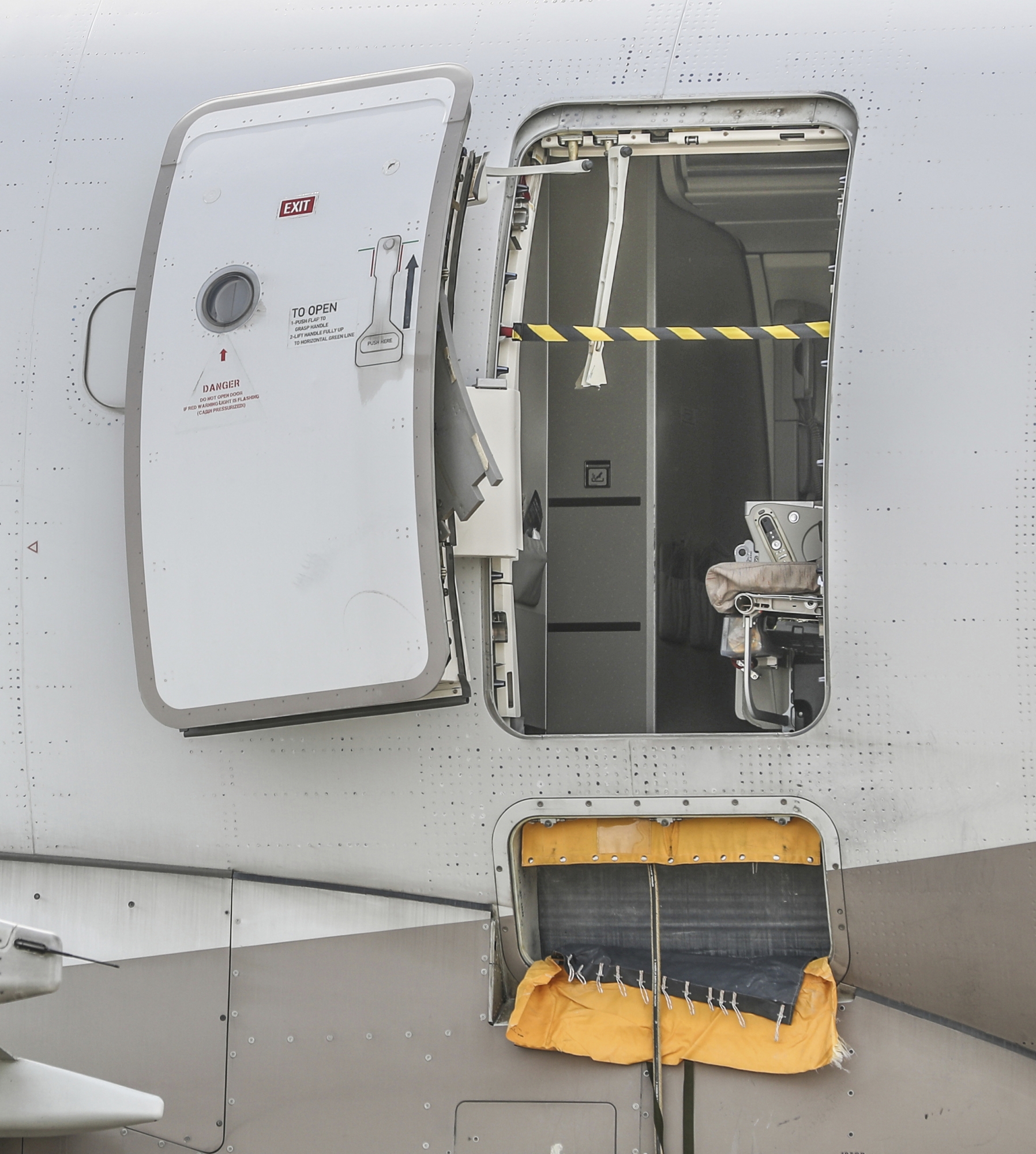 An emergency exit door of an Asiana Airlines plane is seen at Daegu International Airport in Daegu, South Korea, Friday, May 26, 2023, after a passenger opened it during a flight. A passenger opened the emergency exit door during a South Korean flight Friday, causing air to gust inside the cabin before the plane landed safely, airline and government officials said. (Yun Kwan-shick/Yonhap via AP)