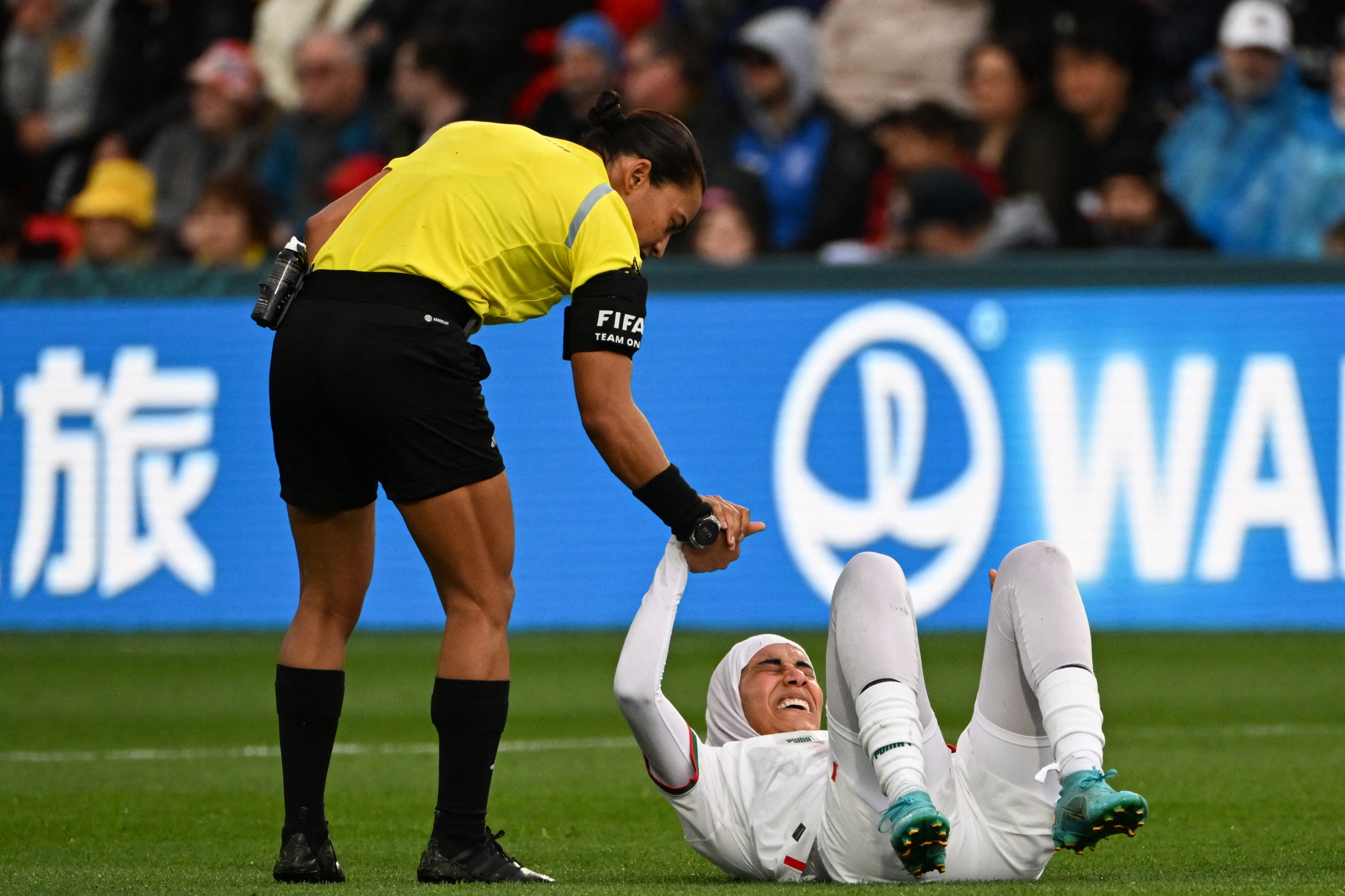 Brazilian referee Edina Alves (L) helps Morocco's defender #03 Nouhaila Benzina to get up after a challenge during the Australia and New Zealand 2023 Women's World Cup Group H football match between South Korea and Morocco at Hindmarsh Stadium in Adelaide on July 30, 2023. (Photo by Brenton EDWARDS / AFP)