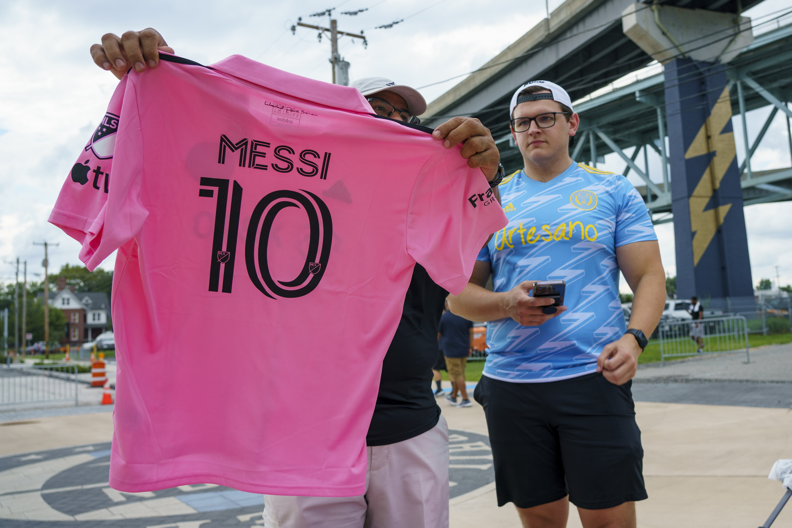 A Philadelphia Union fan looks over an Inter Miami Lionel Messi jersey before a Leagues Cup soccer semifinal Tuesday, Aug. 15, 2023, in Chester, Pa. (AP Photo/Chris Szagola)