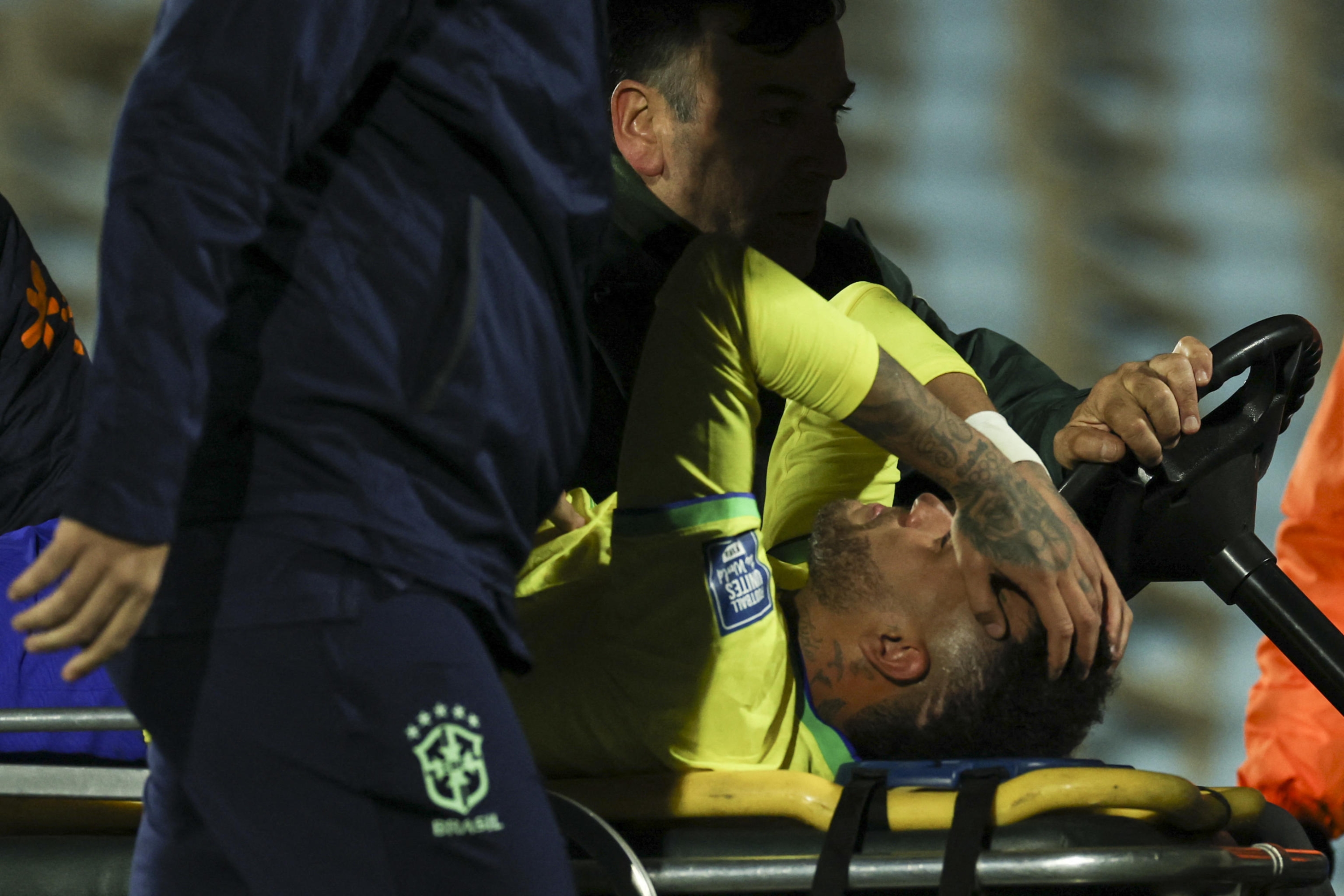 Brazil's forward Neymar leaves the field crying in pain after an injury during the 2026 FIFA World Cup South American qualification football match between Uruguay and Brazil at the Centenario Stadium in Montevideo on October 17, 2023. Football superstar Neymar has a torn ligament and meniscus in his left knee and will have to undergo surgery after being injured during Brazil's 2-0 loss to Uruguay, the Brazilian Football Confederation (CBF) said on October 18. (Photo by Pablo PORCIUNCULA / AFP)