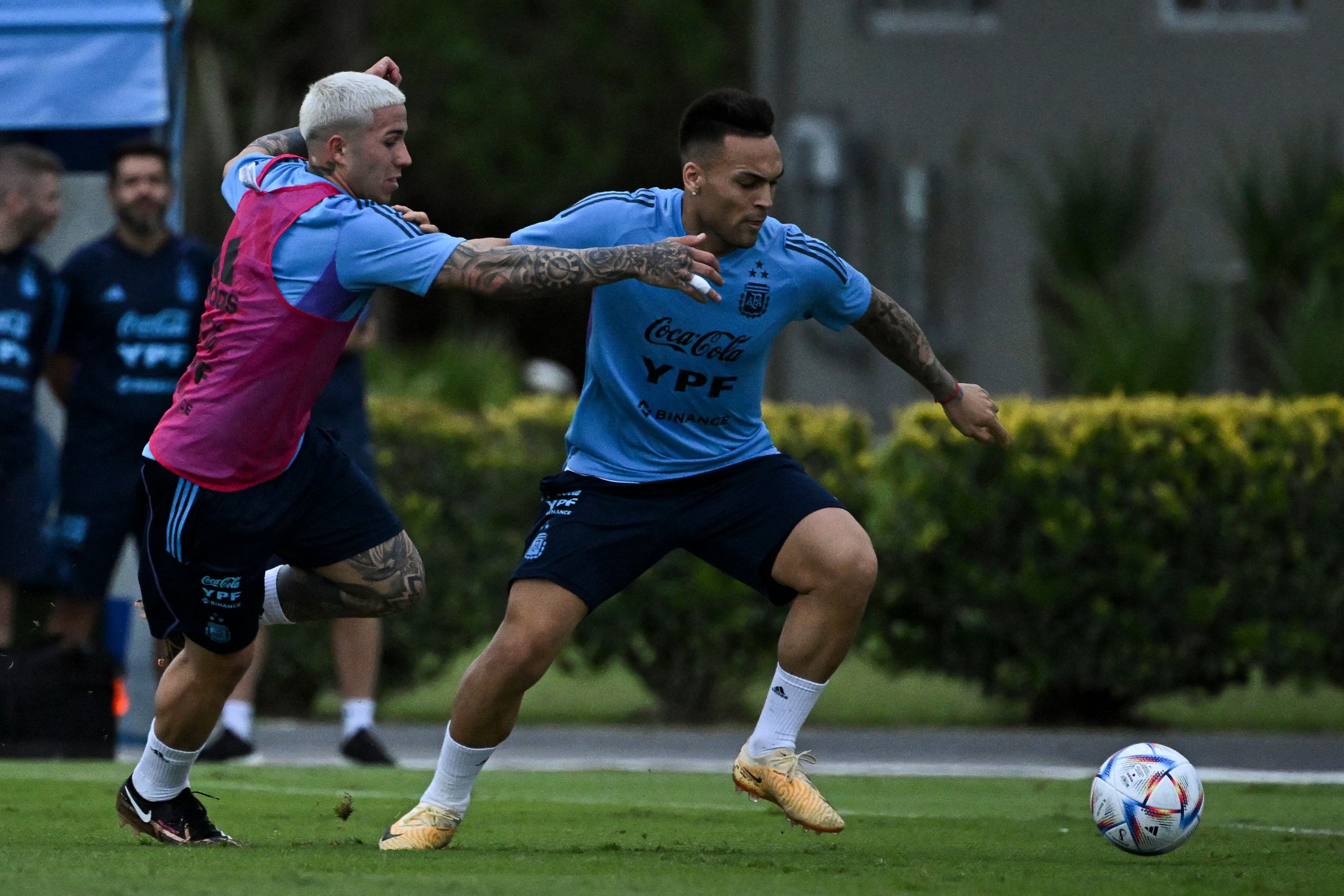 Argentina's midfielder Enzo Fernandez (L) vies for the ball with his teammate forward Lautaro Martinez (R) during a training session in Ezeiza, Buenos Aires province, on March 22, 2023, ahead of the friendly football matches against Panama and Curazao. (Photo by Luis ROBAYO / AFP)
