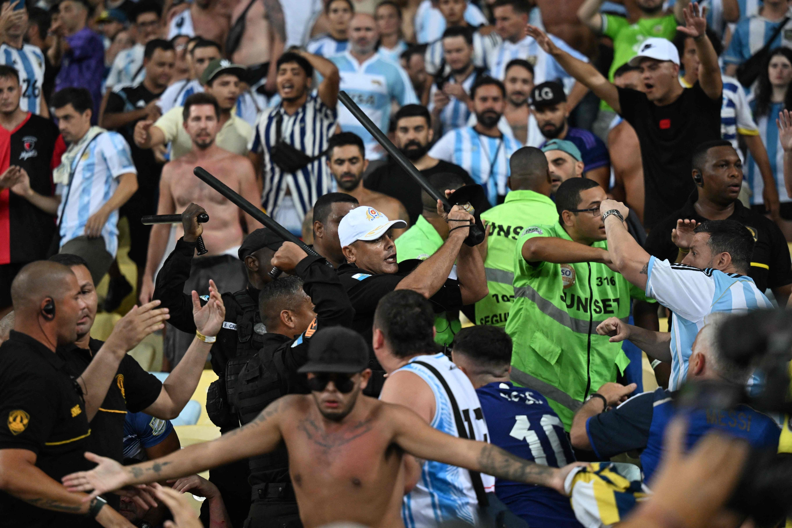 Fans of Argentina clash with Brazilian police before the start of the 2026 FIFA World Cup South American qualification football match between Brazil and Argentina at Maracana Stadium in Rio de Janeiro, Brazil, on November 21, 2023. (Photo by CARL DE SOUZA / AFP)